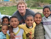 An American traveller with local kids in Ghor, near the Dead Sea of Jordan
