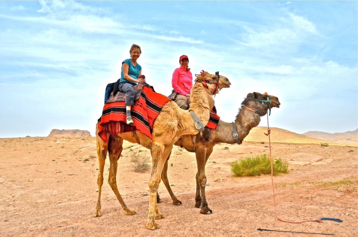 Women riding camels on the back route to Petra, Jordan