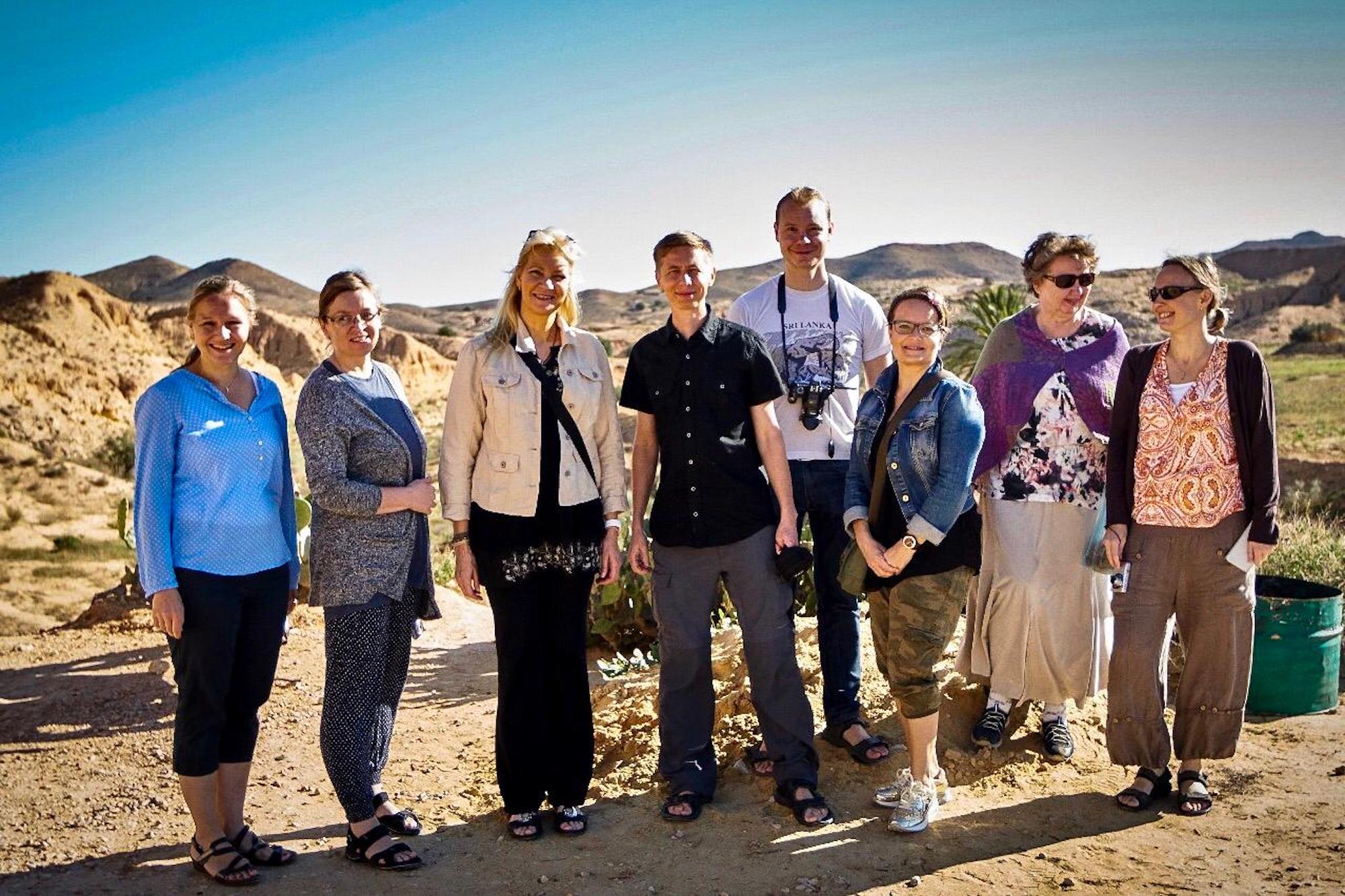 Group of travelers posing in Matmata Tunisia with desert landscape in the background