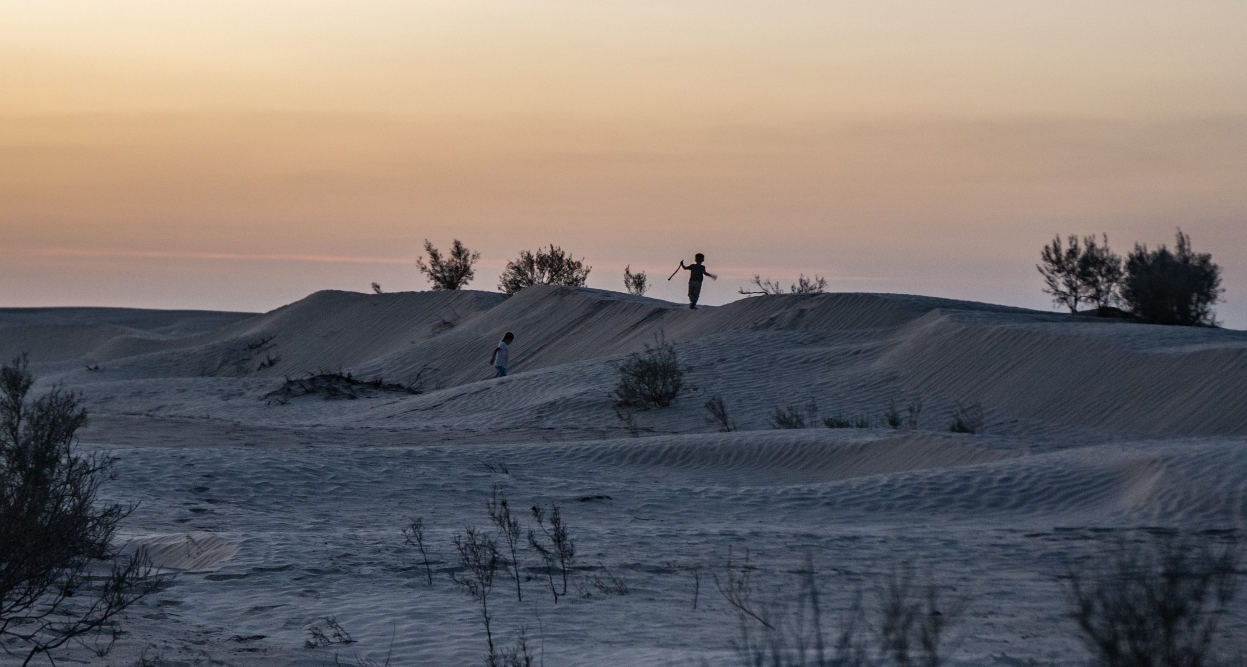 Children play in the dunes of the Tunisian Sahara Desert