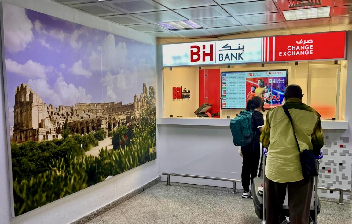 A man waits in line at a currency exchange kiosk in the Tunis airport